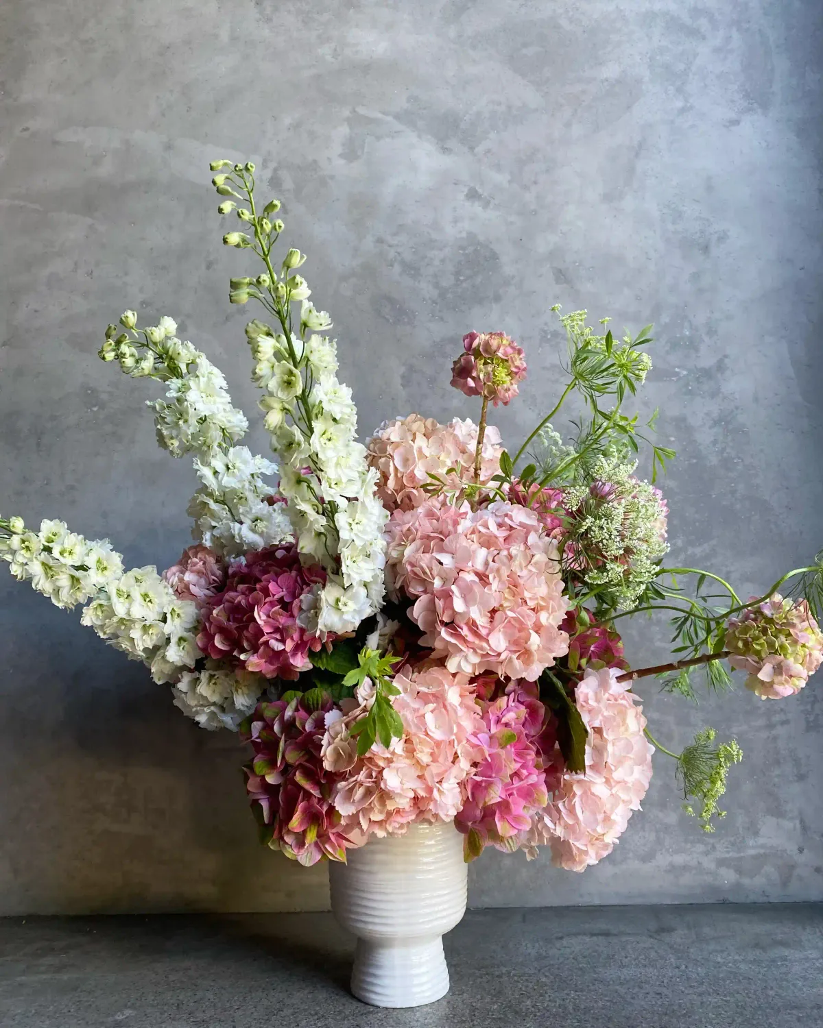 One and Only Valentine's arrangement with pink hydrangeas garden roses and white delphinium in ceramic vase San Francisco