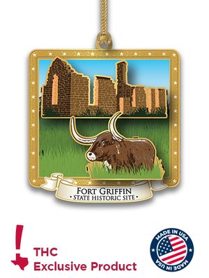 Holiday ornament of a Texas longhorn with fort ruins in the background. Bottom of image shows THC logo and made in USA logo.