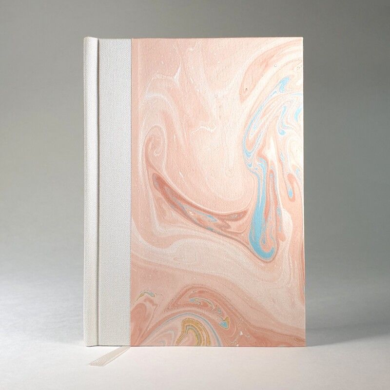 Handgefertigtes Notizbuch mit Marmorpapier in Rosa- und Blautönen und weißem Leinenrücken