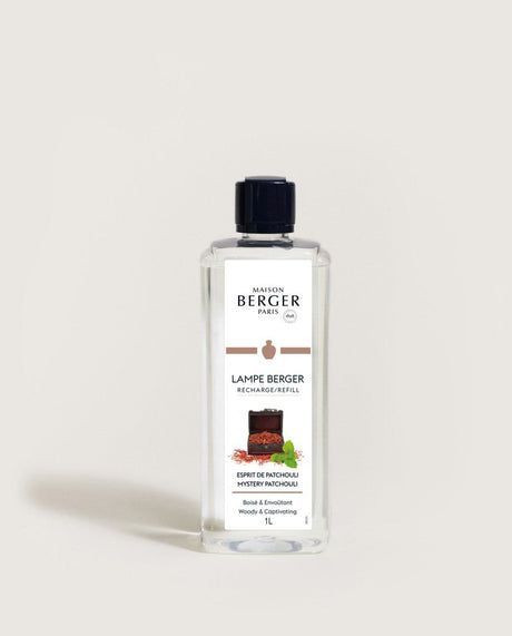 Clear bottle of Maison Berger lamp fragrance with brown and green imagery.