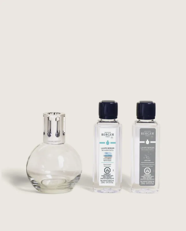 Clear glass lamp and two fragrance bottles on a white background.