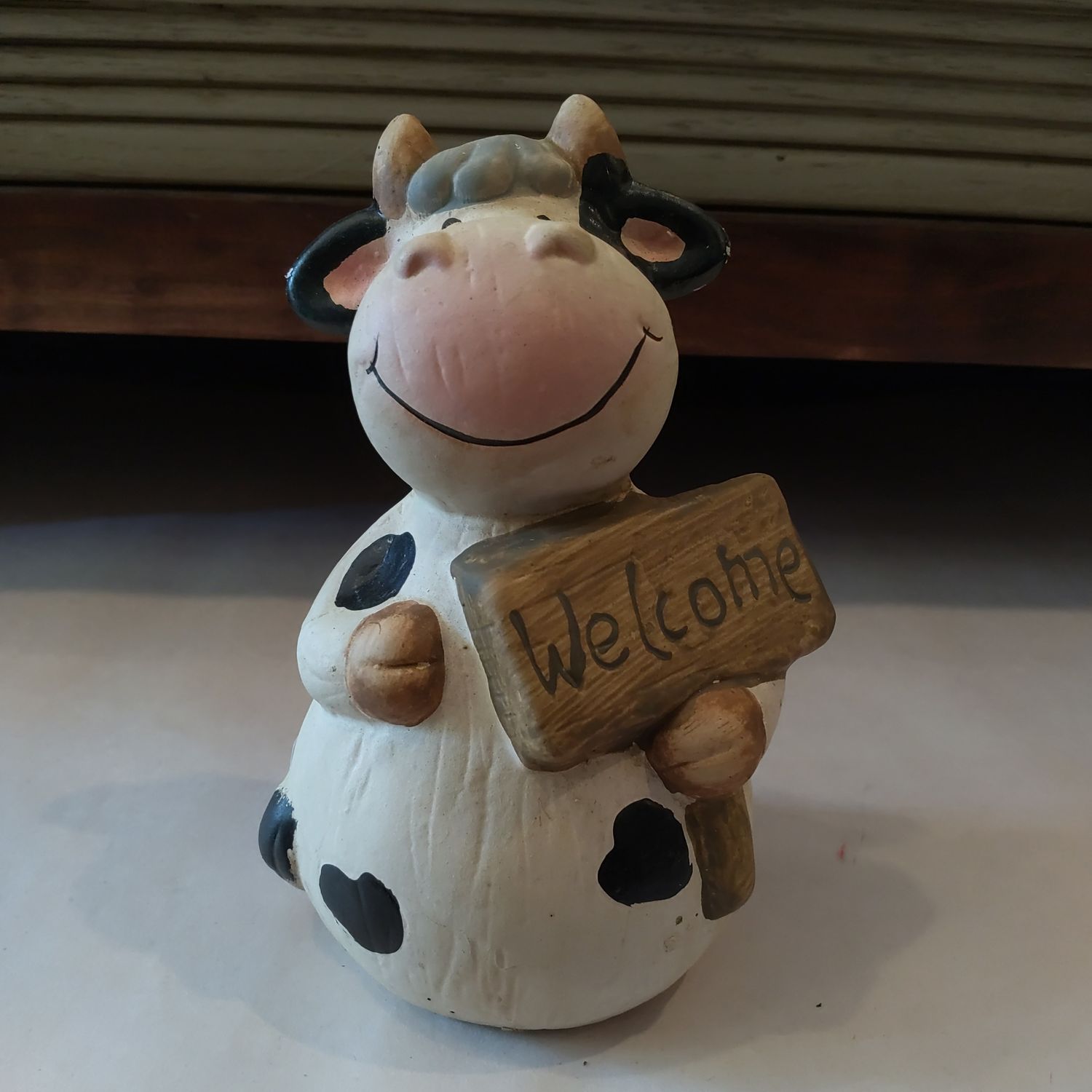 Cow Holding Welcome Sign