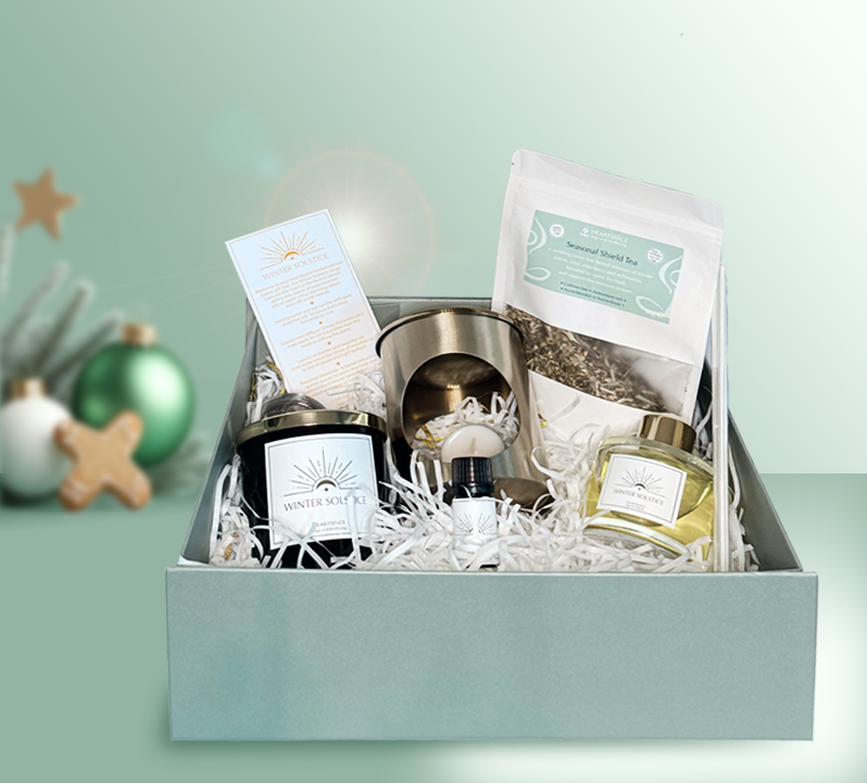 Product shot of HeartSpace 'Winter Solstice' luxury gift box with candle, diffuser, oil, burner, tea on festive background.
