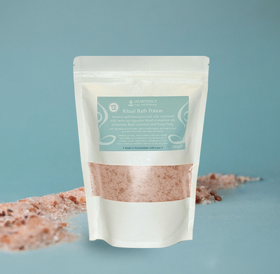 HeartSpace Bath Potion Product shot of HeartSpace Bath Potion in white paper bag with window exposing pink Himalayan salts.