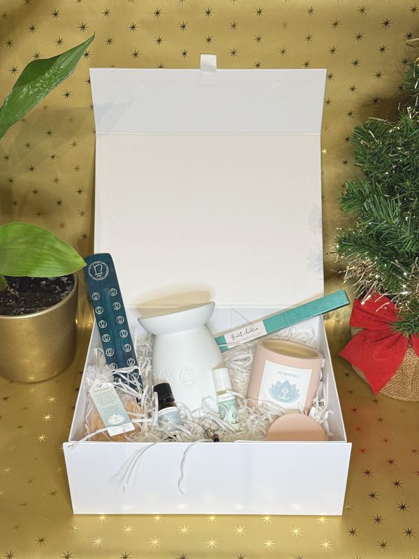 Product shot of open HeartSpace gift box containing candle,  incense, incense holder, essential oil, bath potion, oil burner.