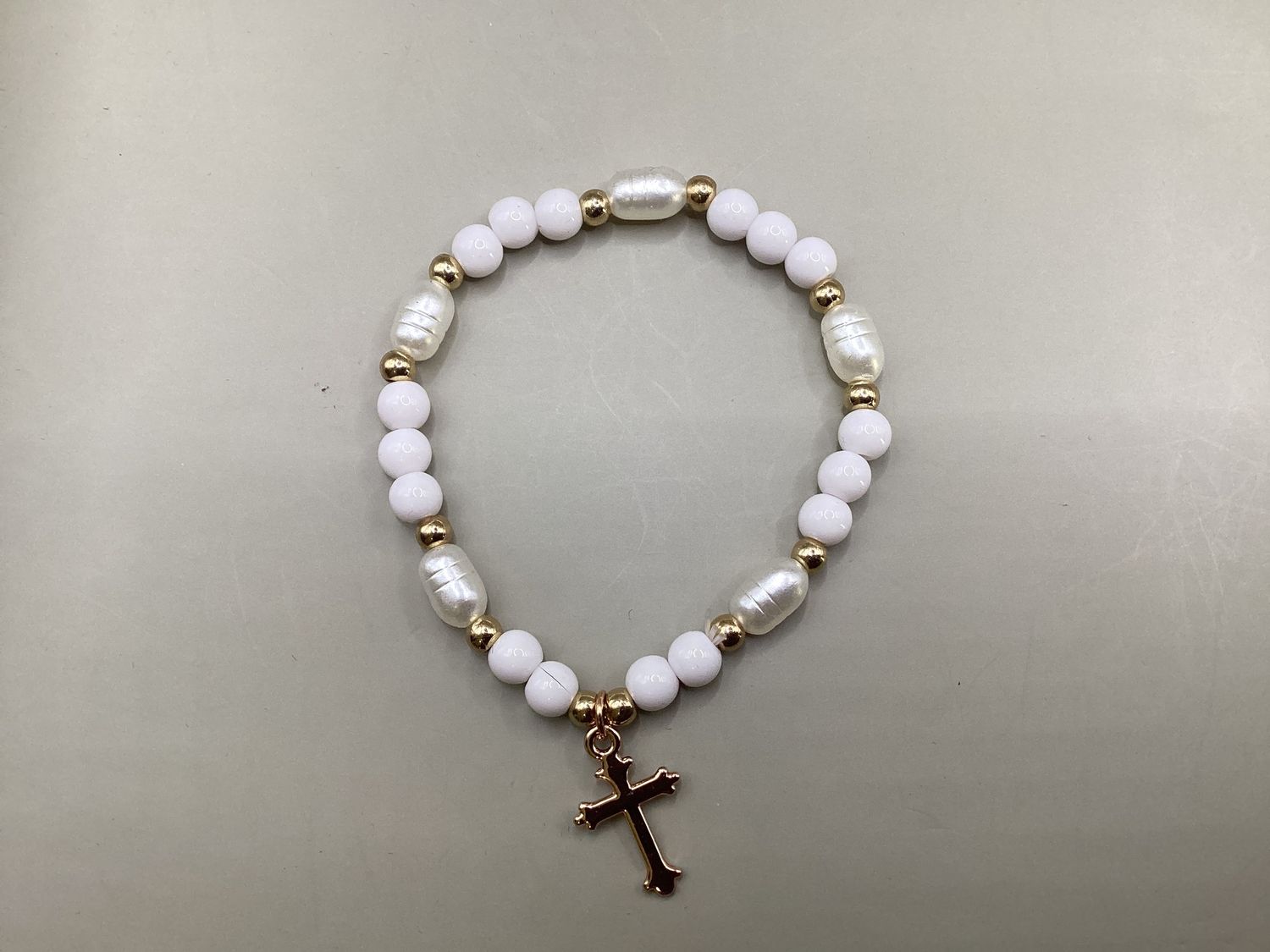 White stretchy bracelet with gold-tone Cross