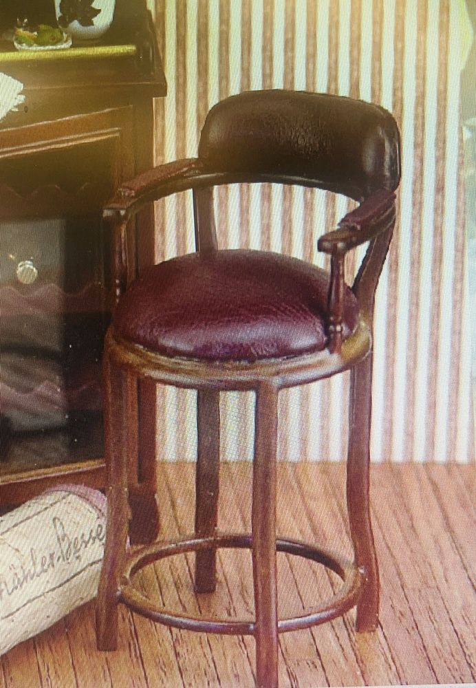 Wooden bar stool with red leather upholstery.