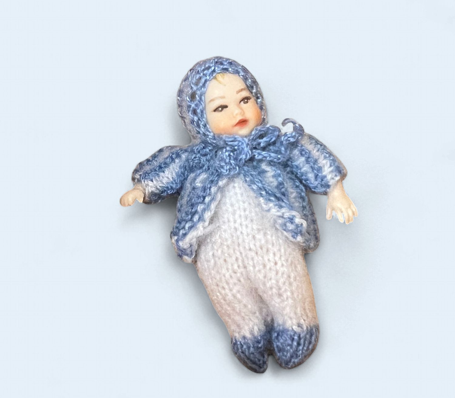 Heidi Ott baby in white jumper/blue hooded sweater
