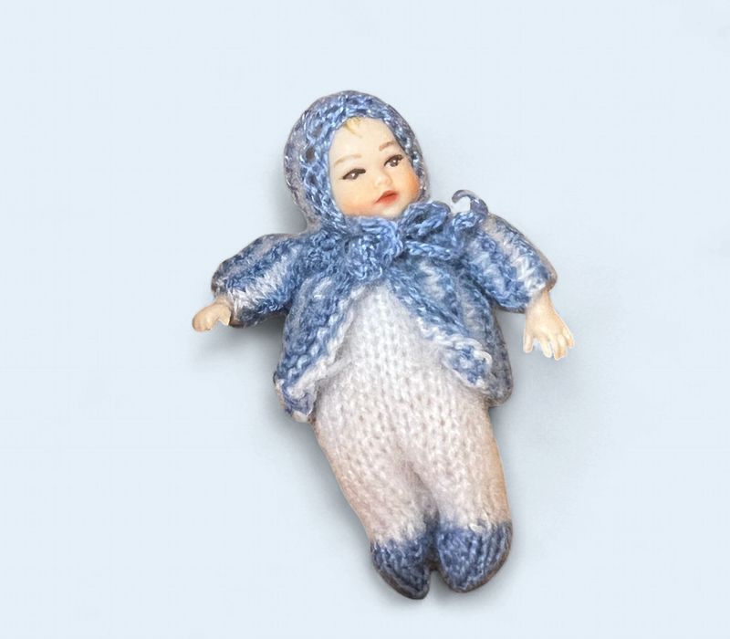 Heidi Ott baby in white jumper/blue hooded sweater