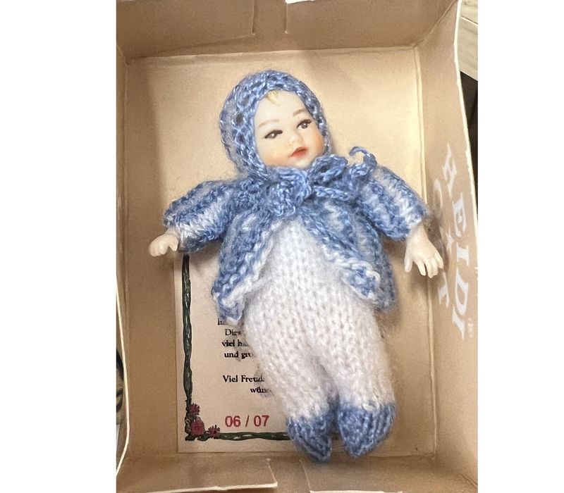 Heidi Ott baby in white jumper/blue hooded sweater