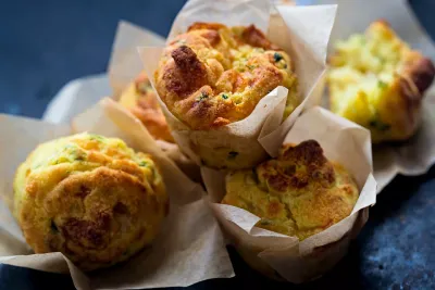 Muffin salati al formaggio, preparati con Protein Bake Mix Herbalife, disposti su carta da forno, pronti per essere gustati.