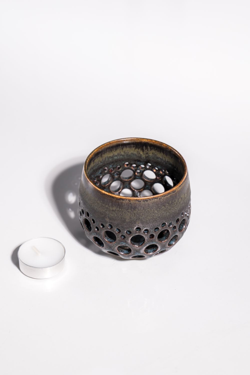 Daisy pattern organic volcanic candleholder with variated finish. Handmade by local artist and hand thrown on pottery wheel. 