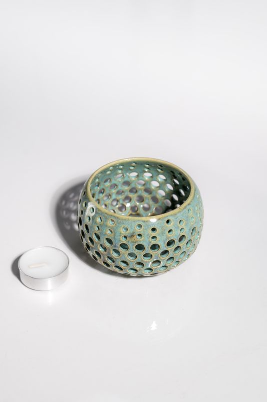 Handmade ceramic candleholder with numerous pierced holes. Made by hand for candle lovers.