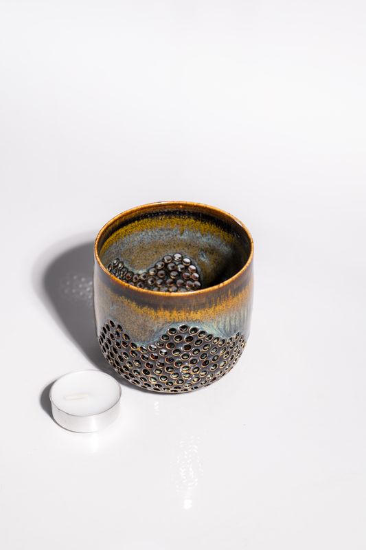 Wavy pattern ceramic stoneware candleholder for votive or tealight candle. Hand made with pierced walls to shine light
