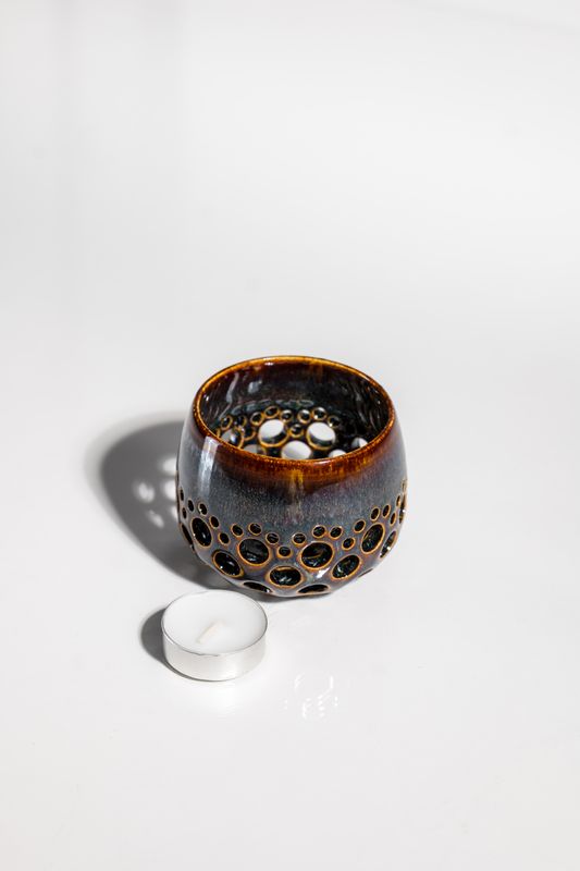 Blue and brown ceramic votive tealight candleholder designed to illuminate a room and cast shadows along the walls. Handmade