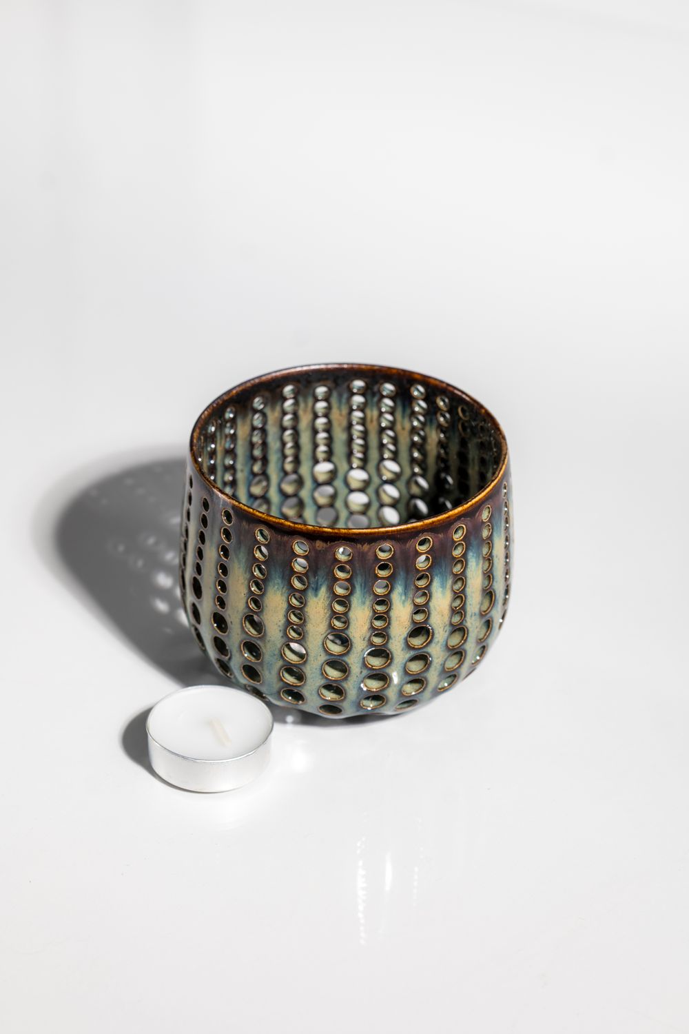 Ceramic tealight candleholder with brown base and dripping blue topcoat glaze. Variable finish from gloss to matte.