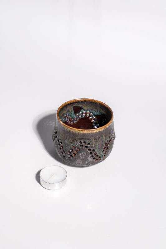Organic flowing ceramic candleholder with hand-carved holes and thrown on the wheel. Designed for votive or tealight candle. 