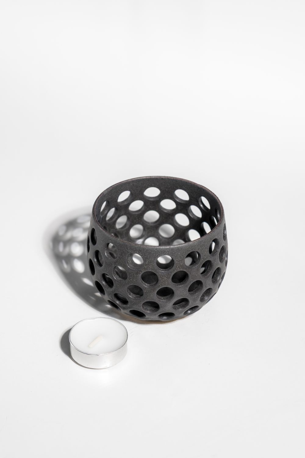 Matter black ceramic tealight candle holder with holes for ambient lighting. Handmade by CORTERRA ideal for MCM home.