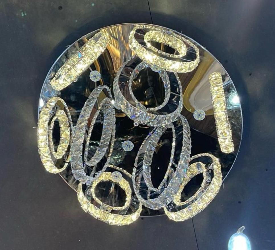 Modern let lamp ceiling light with LED, silver and gold curling design on circular mirrored base, providing ambient lighting for living or TV room.