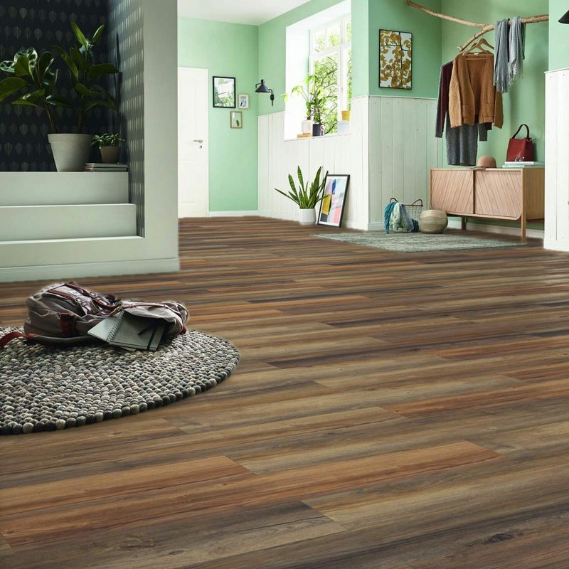 Laminat in rustikaler Eichenholzoptik. In Braun- und Grautönen gefärbt. Raumfoto eines großen Flurs…