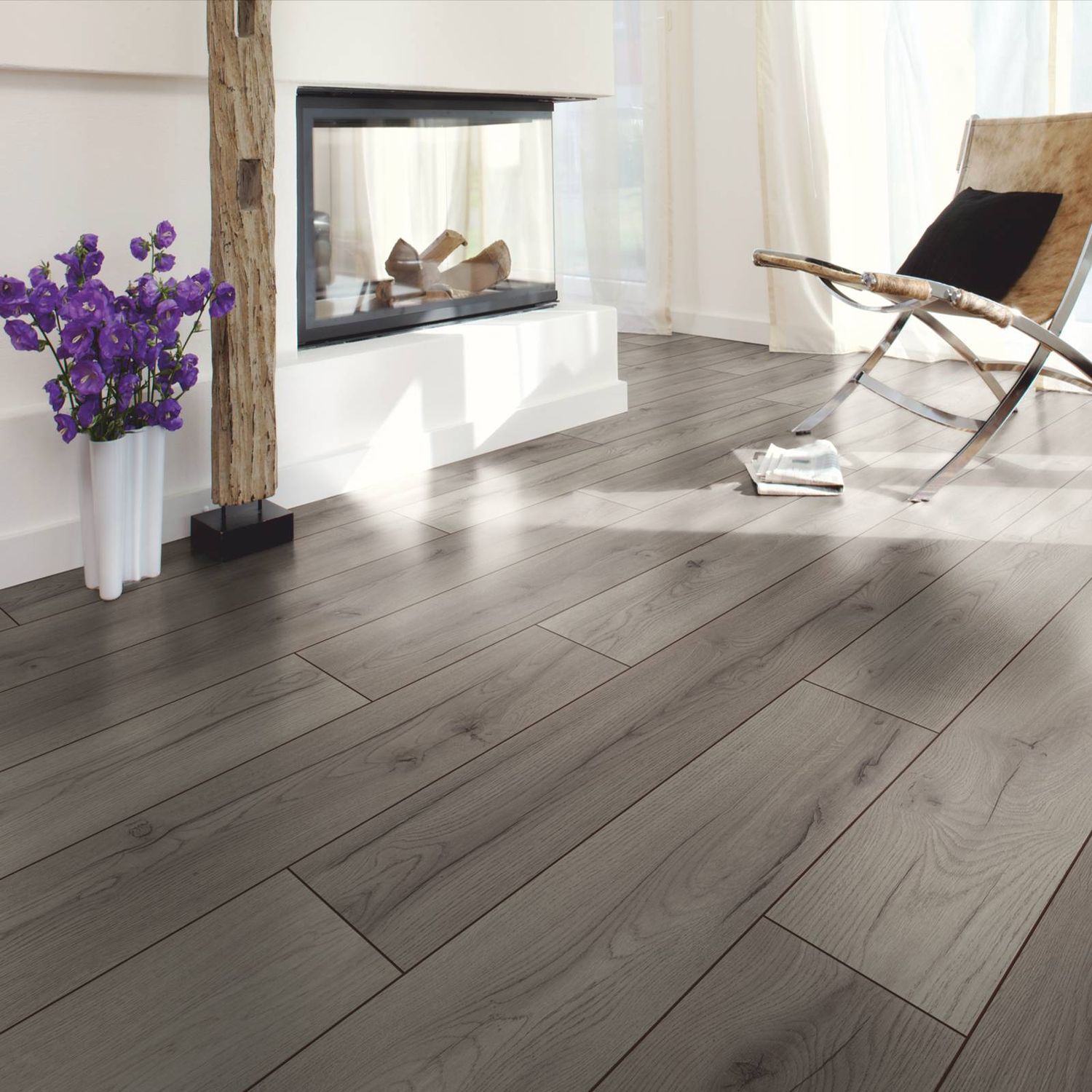 Laminat in dunkelgrauer und rustikaler Holzoptik in einem Wohnzimmer mit Kamin.