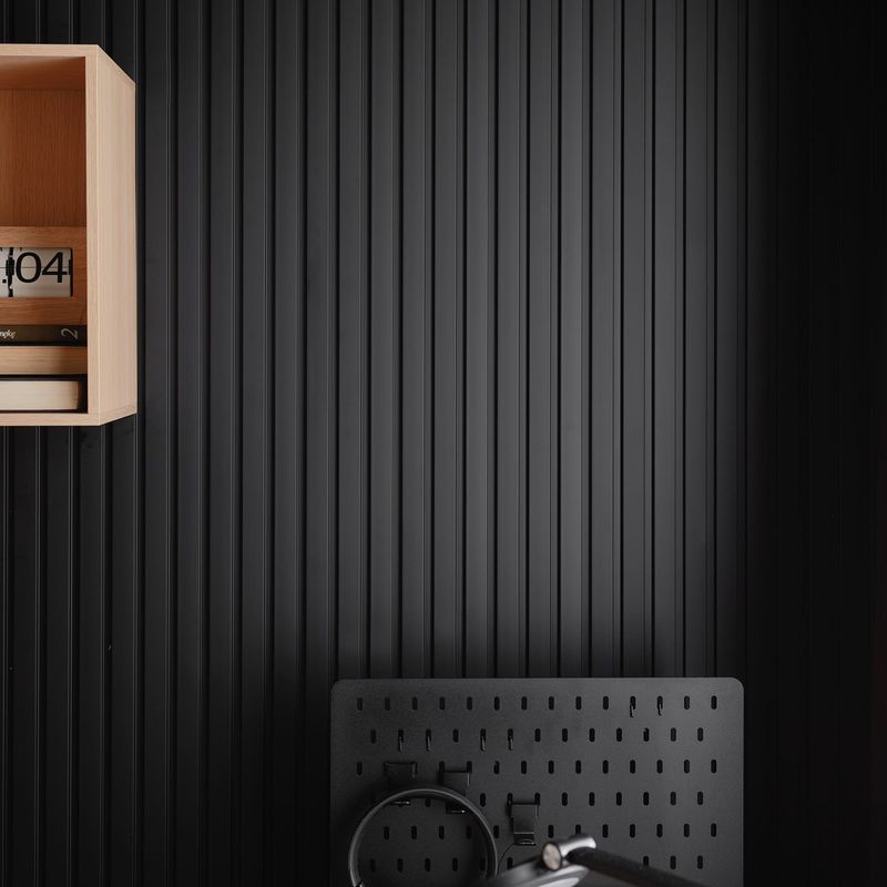 Akustikpaneel in Schwarz mit einem hellbraunen Wandregal