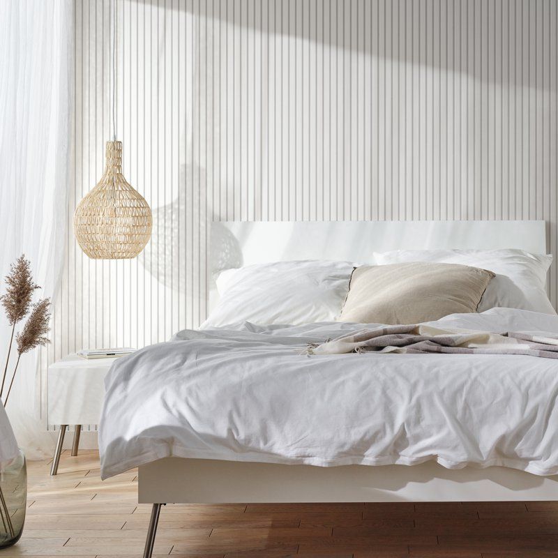 Akustikpaneel in weißer Farbe mit mitteldicken Stäben in einem weißen Schlafzimmer mit hellbraunen Akzentfarben