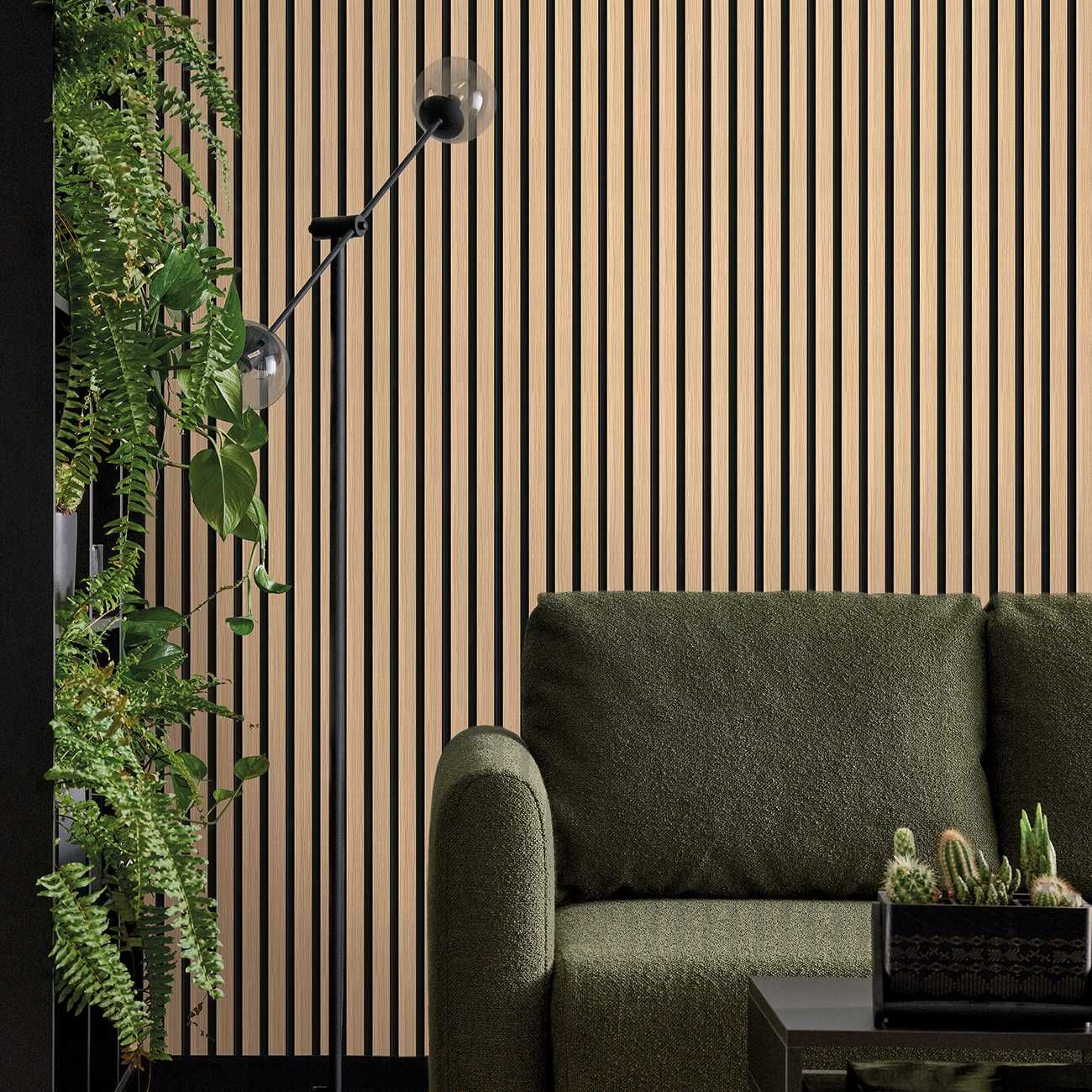 Akustikpaneel in hellbraun und schwarz hinter einer grünen Couch und einem schwarzen Beistelltisch. Links ist eine Pflanze
