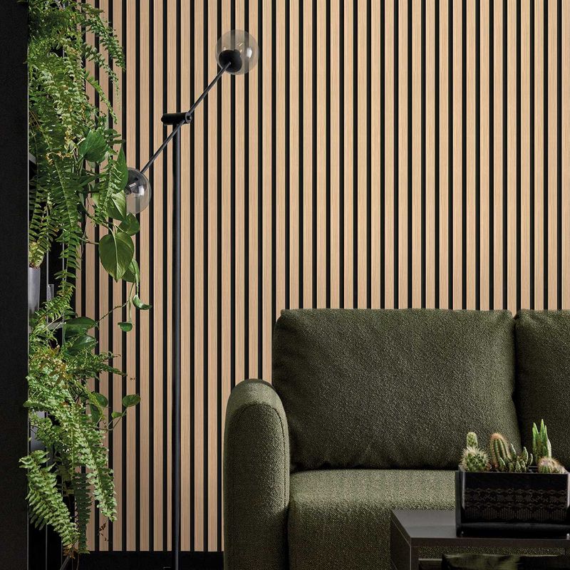 Akustikpaneel in hellbraun und schwarz hinter einer grünen Couch und einem schwarzen Beistelltisch. Links ist eine Pflanze