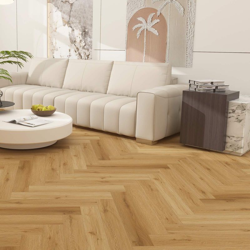 Klebe-Vinylboden im Fischgrät Format in brauner Holzoptik in einem Wohnzimmer mit weißer Couch