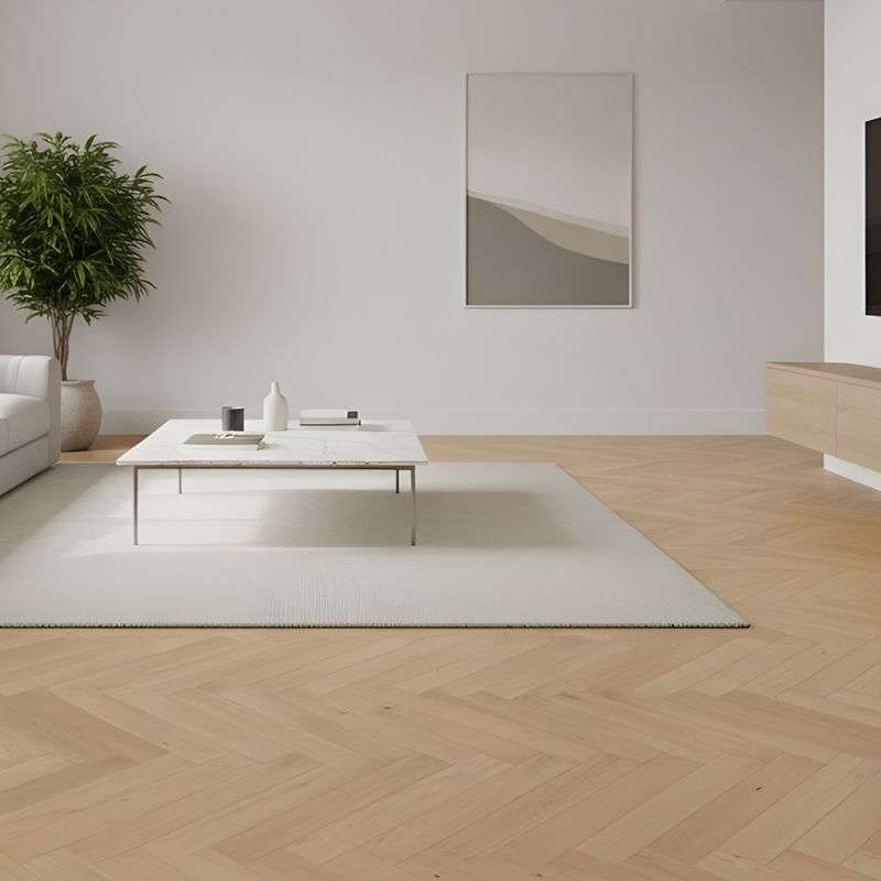 Parkettboden im Fischgrät-Format in heller und brauner Eichenholzoptik in einem offenen und minimalistischen Wohnzimmer