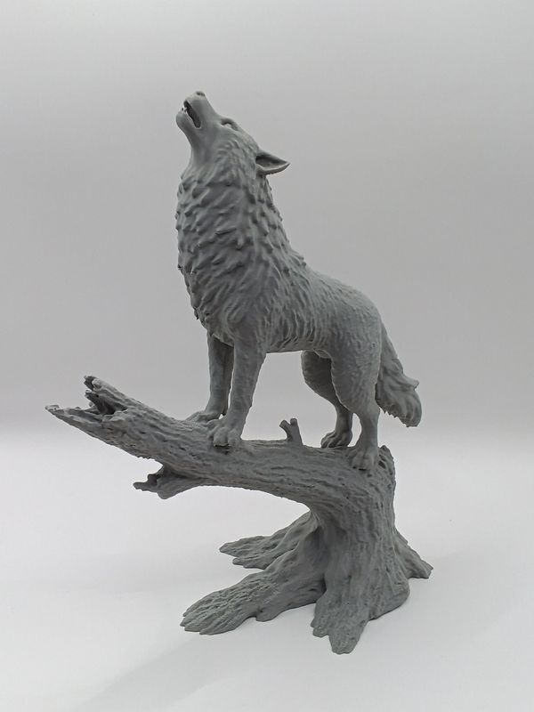 stehender Wolf auf Baumstamm