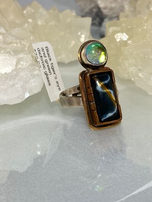 Black tiger’s eye and green dichroic glass with copper and brass bezel