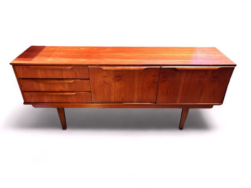 E152 - MCM Sideboard made in England with three drawers, one swing door and one drop door