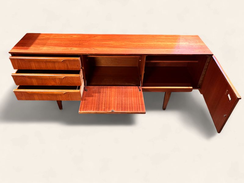 E152 - MCM Sideboard made in England with three drawers, one swing door and one drop door