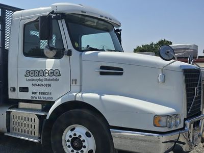 Soracco delivery truck cab lettered with the company name and phone number, parked under a clear sky.