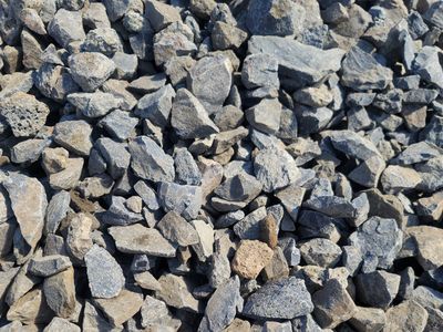 Stockpile of two and a half inch angular basalt chips, sold by the yard at wholesale bulk pricing.