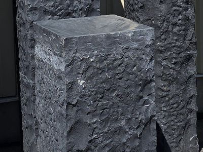 Chiselled black basalt pedestal with a polished top, part of the Designer Series stone furniture line.