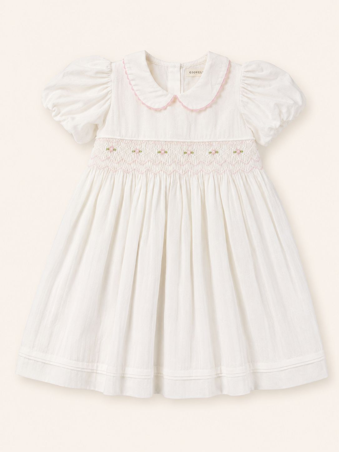 The Rosemere Smocked Dress, a white hand smocked flower girl dress with a Peter Pan collar