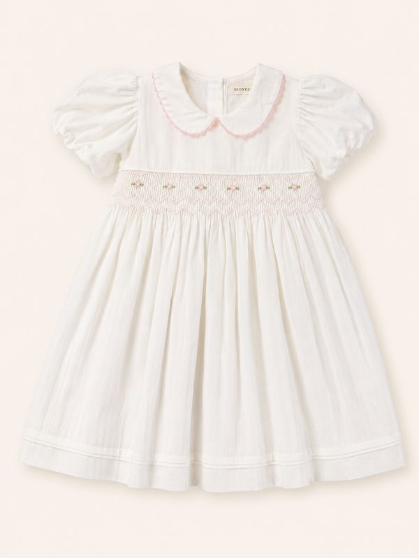 White smocked girls’ dress with puff sleeves, pink collar trim and gathered skirt