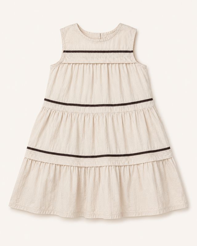 Soft beige girls’ tiered dress with chocolate braided trim and buttoned back keyhole