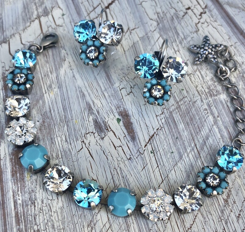 The name of this bracelet is, “A Touch Of Turquoise.“ This bracelet has opal and turquoise flowered elements with Swarovski stones. The setting is antique silver. The name of this bracelet is, “A Touch Of Turquoise.“ This bracelet has opal and turquoise flowered elements with Swarovski stones. The setting is antique silver.