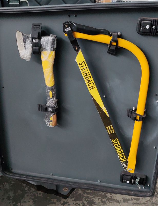 Axe and bow saw mounted in nosebox door