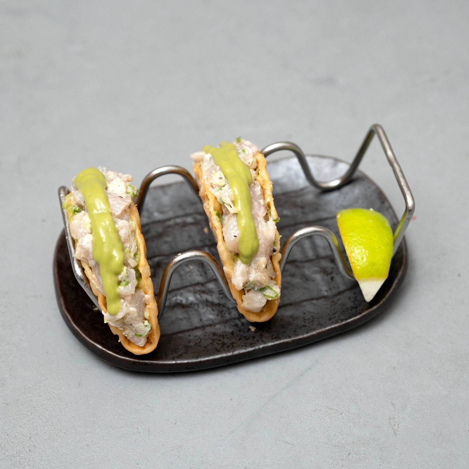 Hamachi Spicy Tacos: Wheat tacos filled with cubed raw Hamachi white fish, traditional guacamole and spicy Jalapeño sauce.