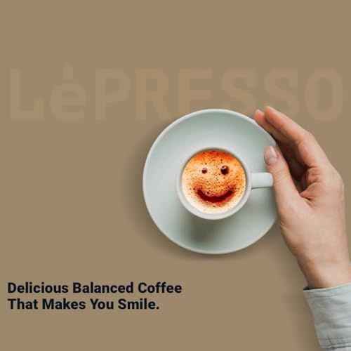 LePresso NS espresso makers coffee cup on a saucer held by a hand with a smiley face design on the …