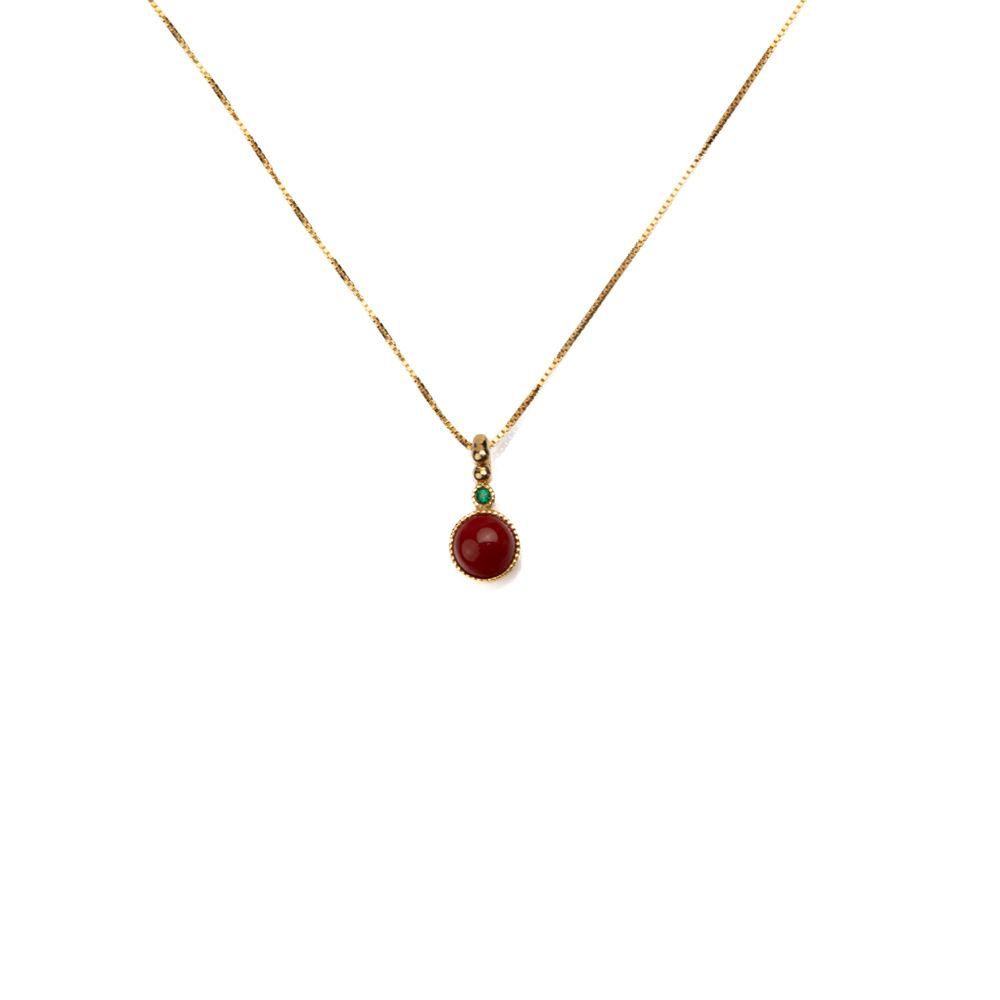 Collana dorata con pendente in corallo rosso e dettaglio verde