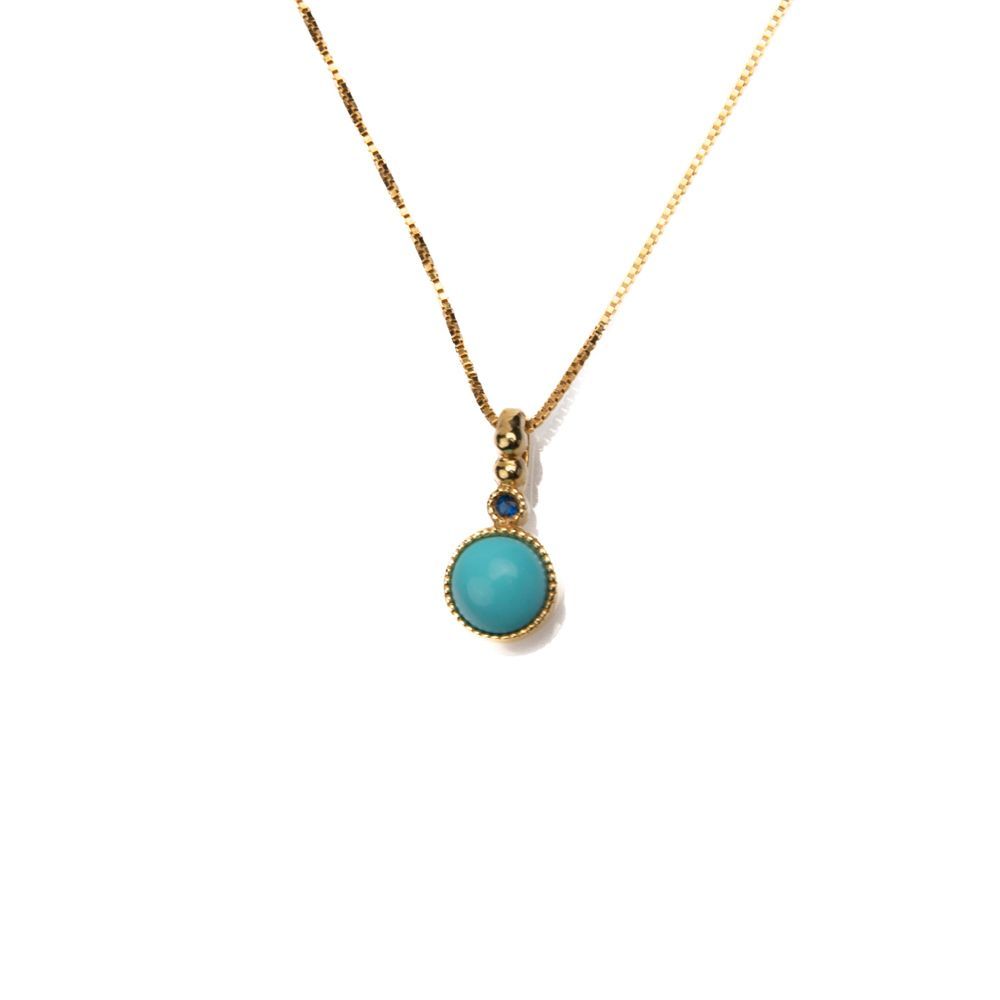 Collana dorata con pendente turchese e dettaglio blu brillante Collana dorata con pendente turchese e dettaglio blu brillante