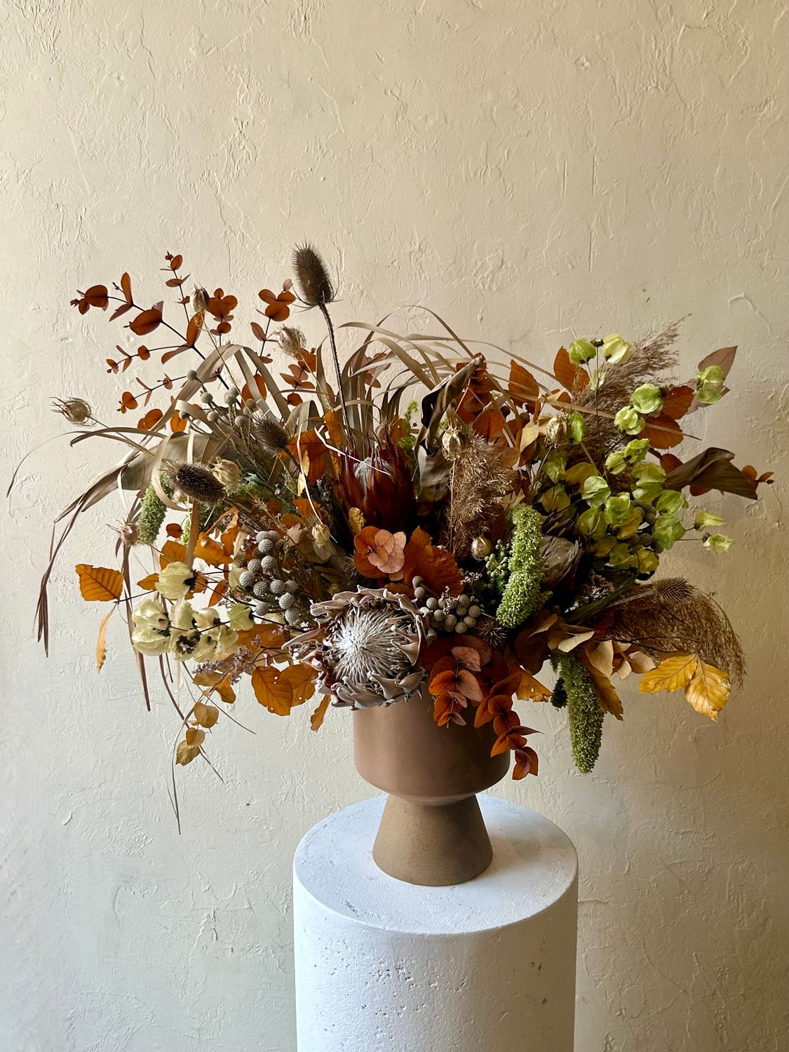 OCHRE DRIED ARRANGEMENT IN FOOTED VASE