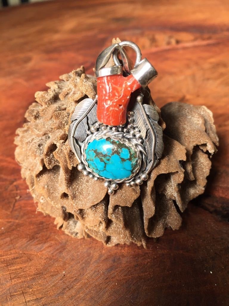 Dije estilo nativo, elaborado con plata 950 acompañado por una turquesa de Arizona y coral rojo de Sargdenia
