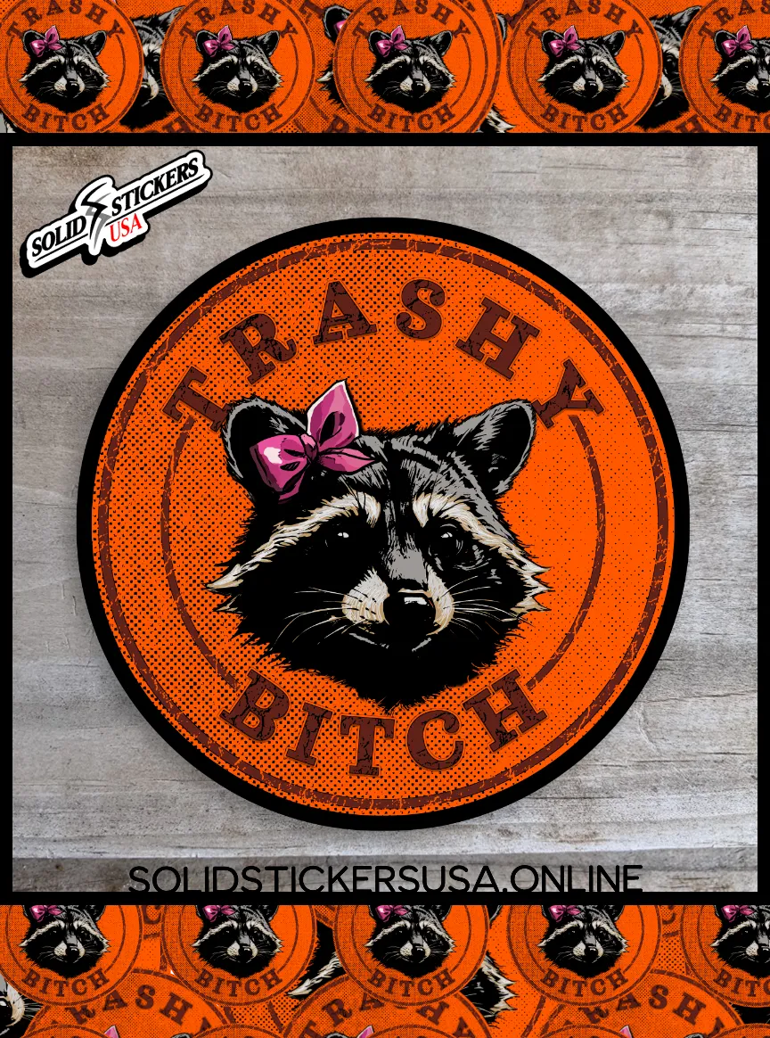 Orange and Black vinyl sticker with the Trashy Bitch Raccoon design on a wooden surface.